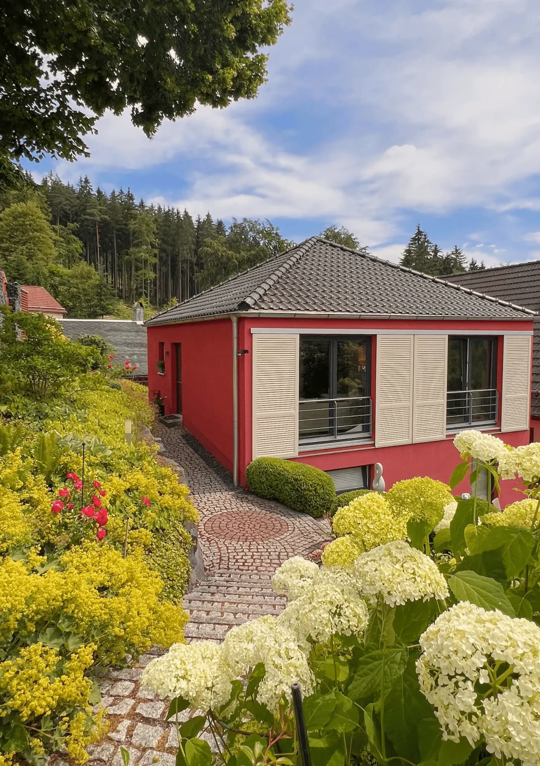 Ferienhaus Conradshöh in Manebach von außen, rotes Haus mit Terrasse und Garten