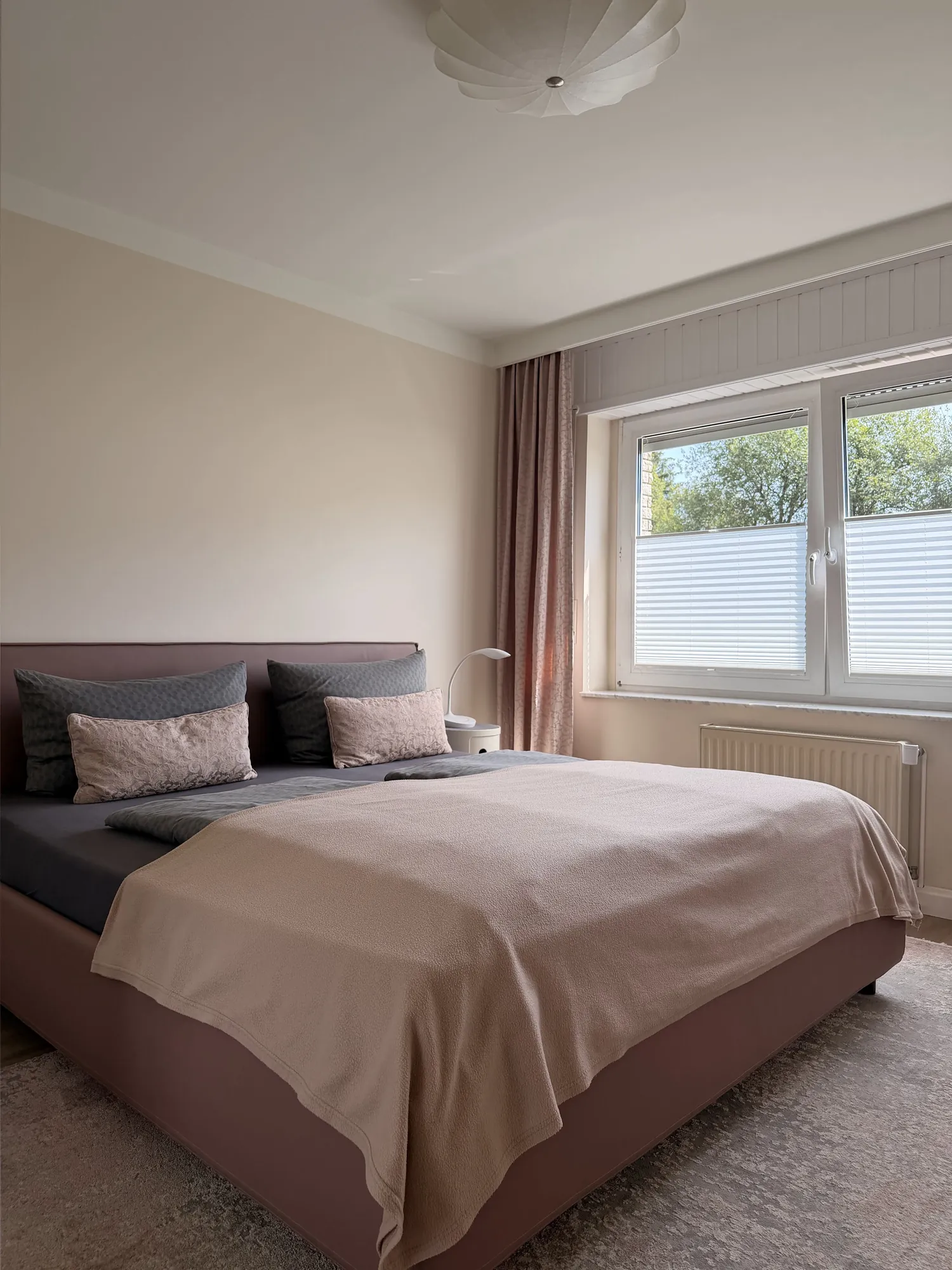 Helles Schlafzimmer mit Doppelbett in Antoinettes Ferienwohnung