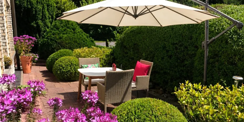 Terrasse mit Sonnenschirm im Garten der Ferienwohnung in Ilmenau-Manebach