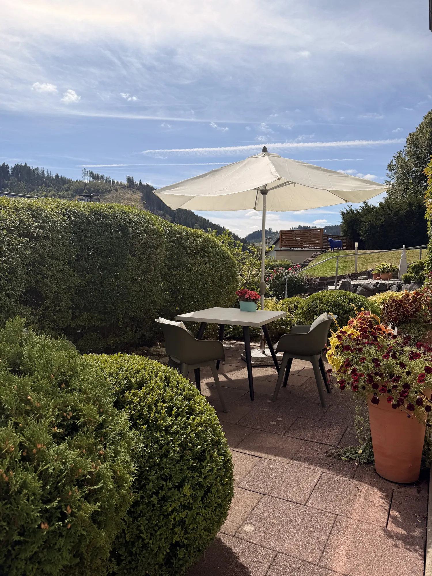 Terrasse mit Sonnenschirm und Blick auf die Berge an Antoinettes Ferienwohnung